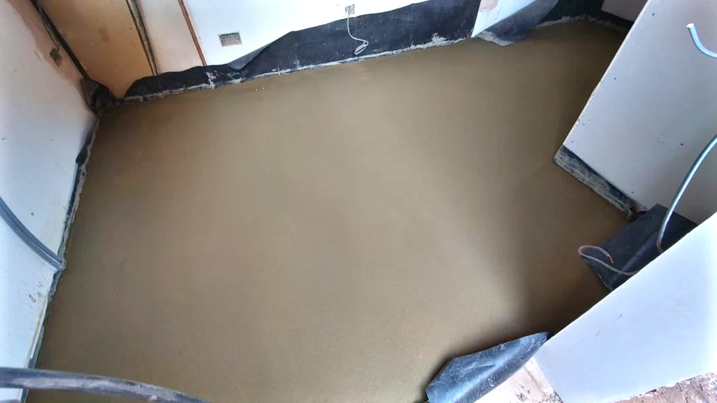 Finished floor screed with membrane still visible at the walls