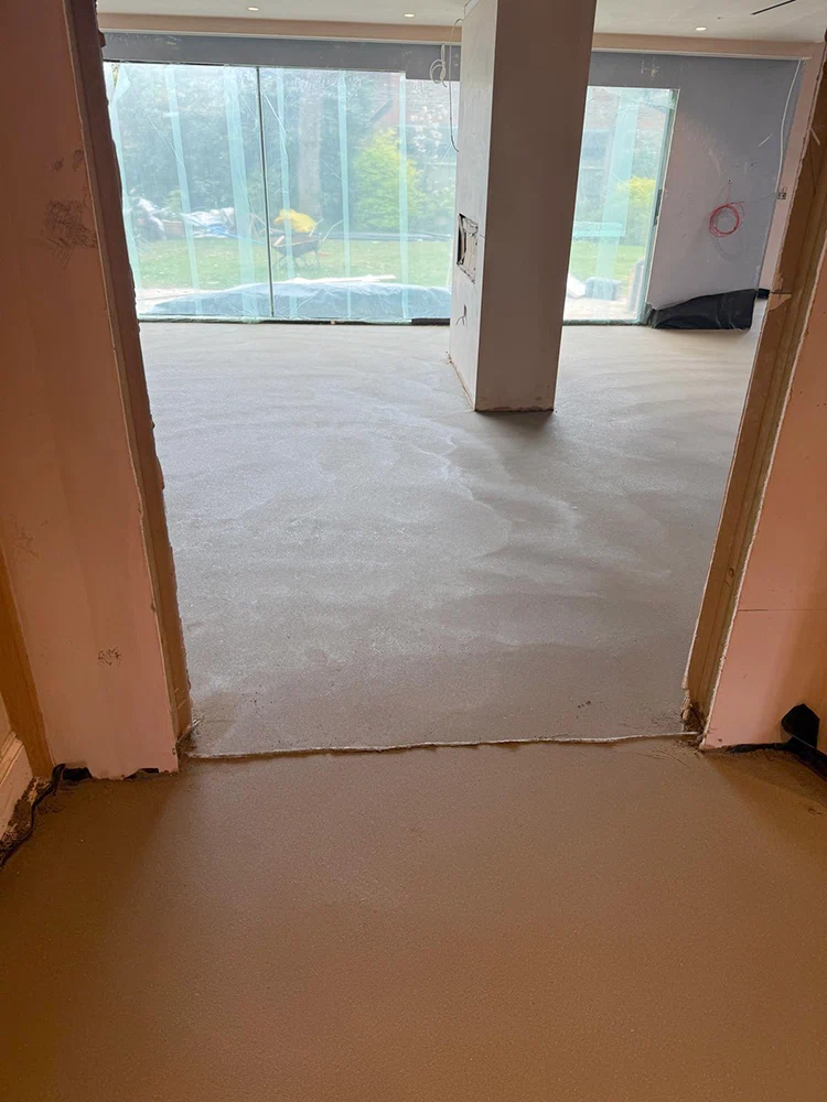 Floor screed through a doorway under warm site lighting