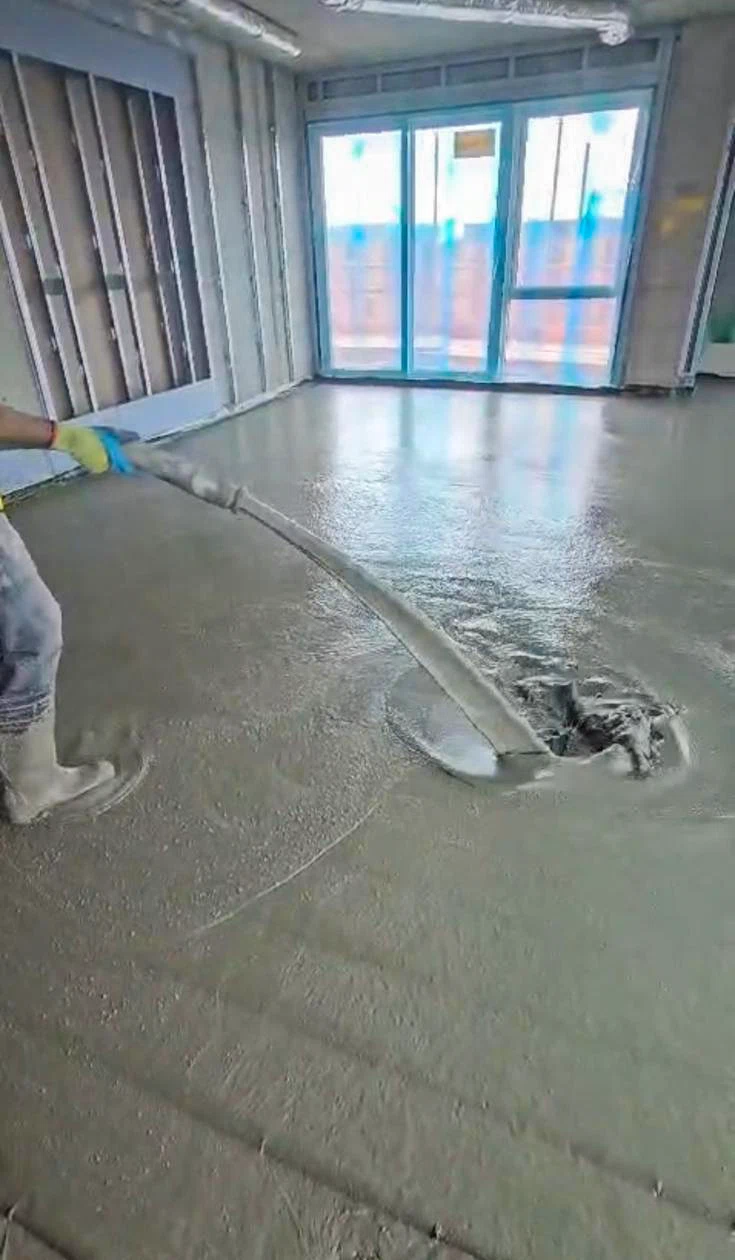 Liquid screed being poured over foil insulation