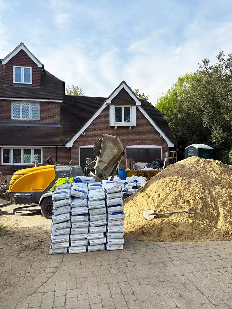 Pallets of cement and sand delivered to a house for screeding