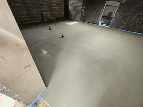 Large floor screed with level markers in place