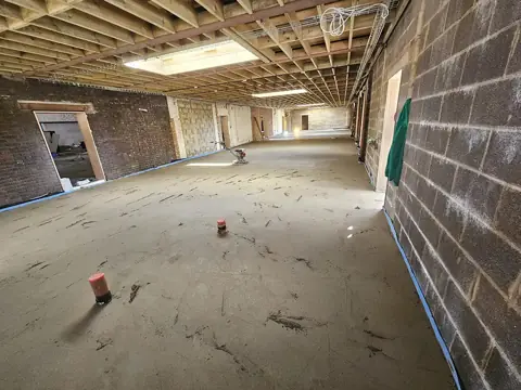 Wide floor screed with depth markers in a large building