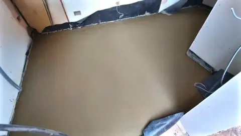 Finished floor screed with membrane still visible at the walls
