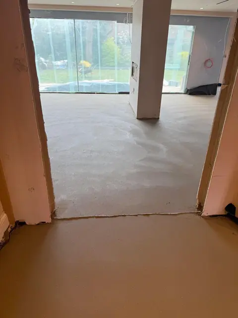 Floor screed through a doorway under warm site lighting