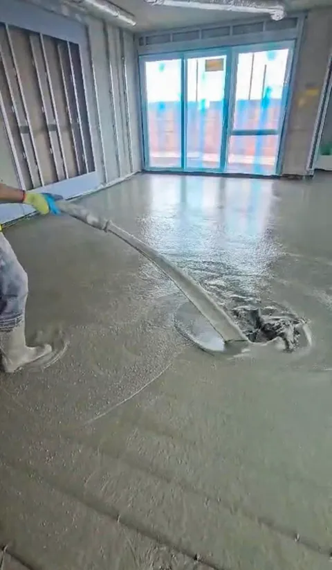 Liquid screed being poured over foil insulation