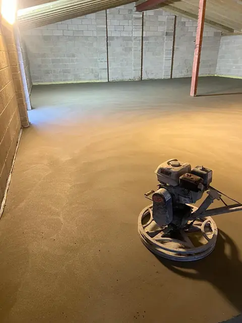Power float on a sand and cement screed in a garage space