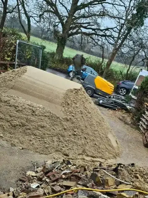 Screeding sand stockpiled on site ready for mixing