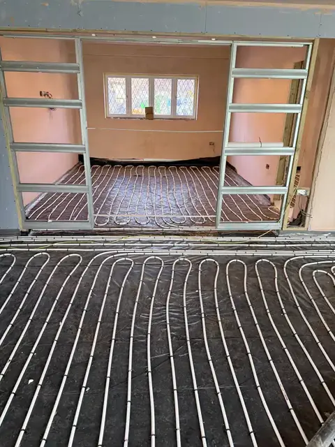 Underfloor heating pipework running between two rooms before screeding