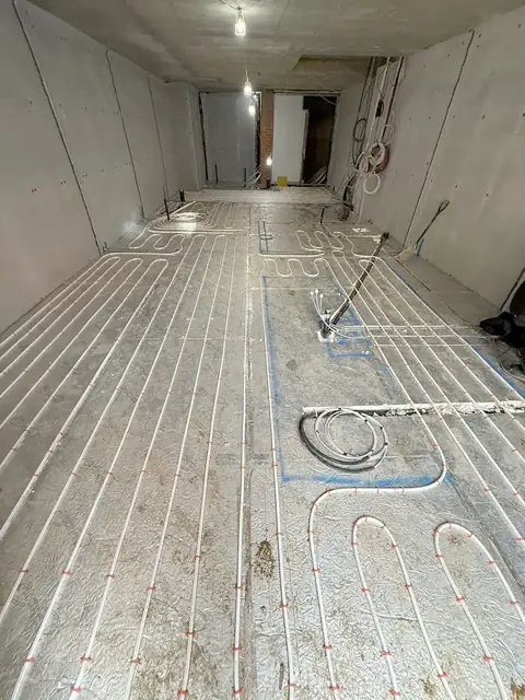 Long run of underfloor heating pipes ready for screed