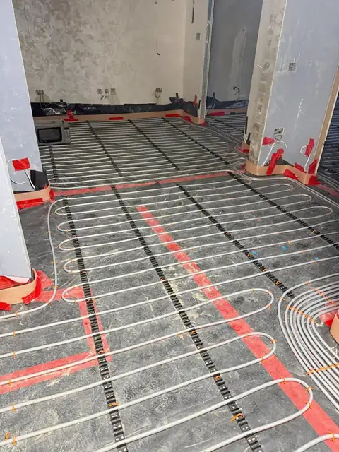 Underfloor heating pipes with red flow pipes before screeding