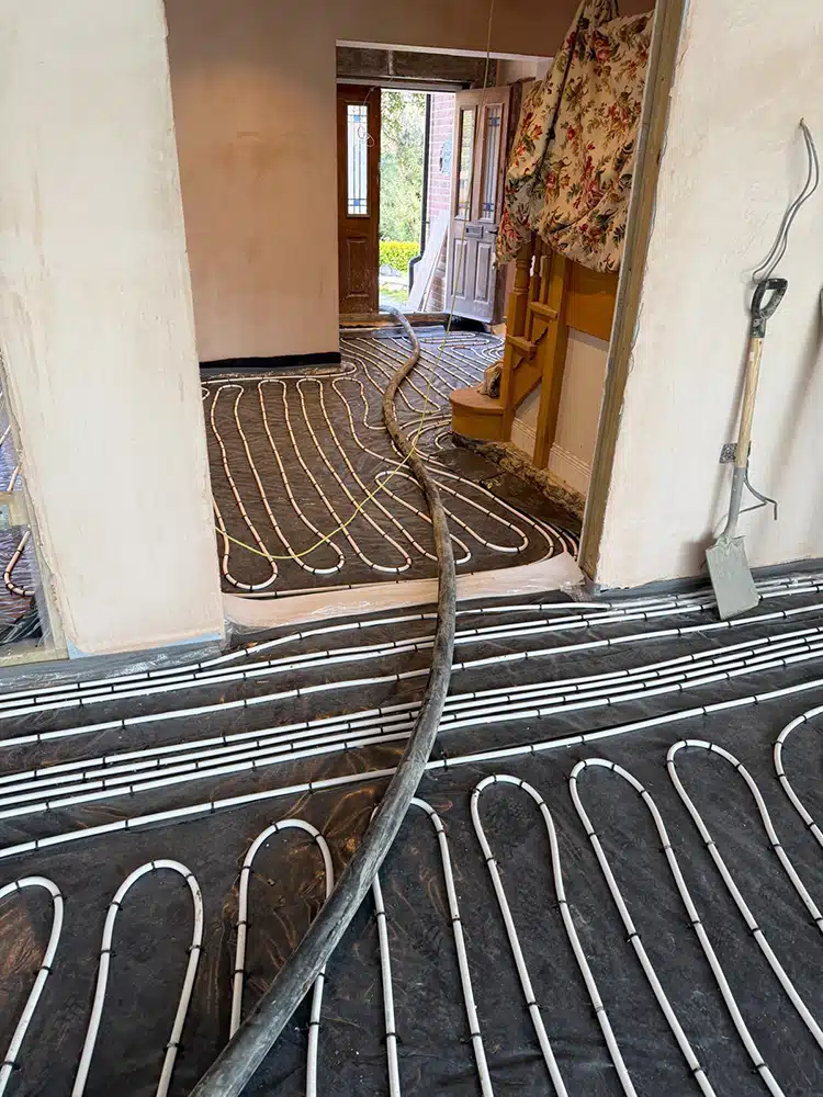 Underfloor heating pipework laid through a doorway before the screed goes down