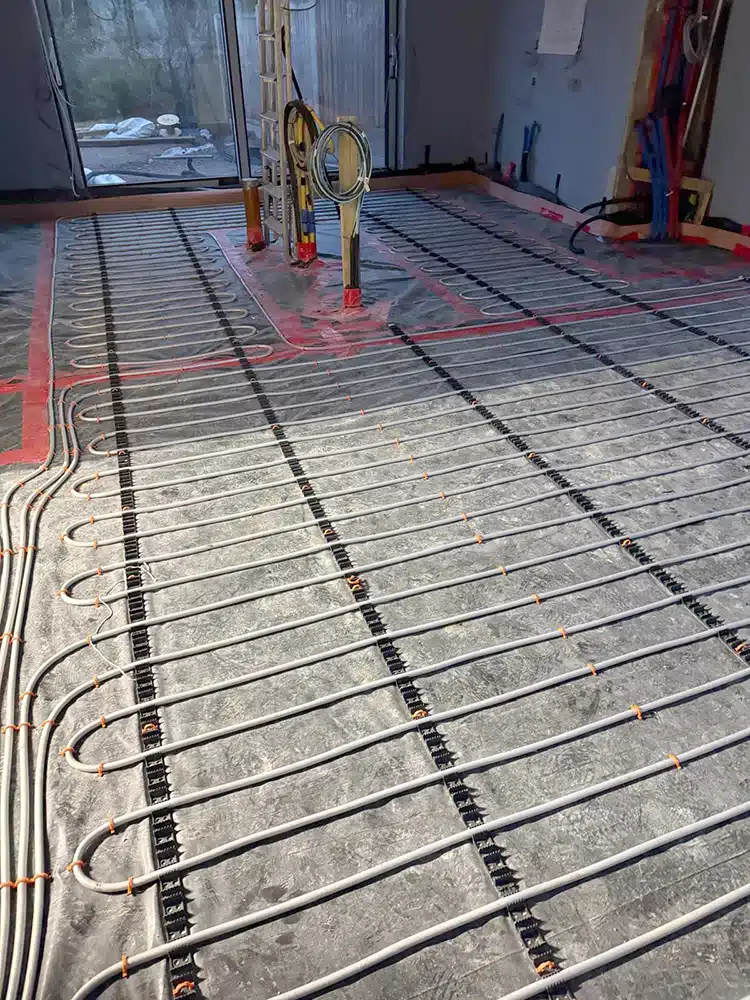 Underfloor heating loops marked out in red before floor screeding