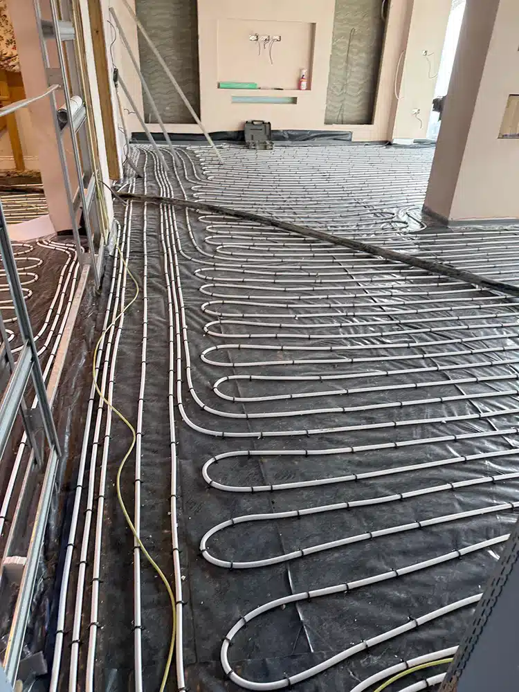 Underfloor heating pipe loops fixed over insulation in a long extension