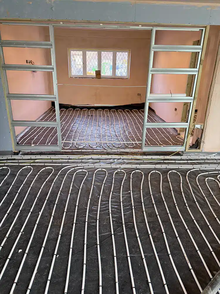 Underfloor heating pipework running between two rooms before screeding