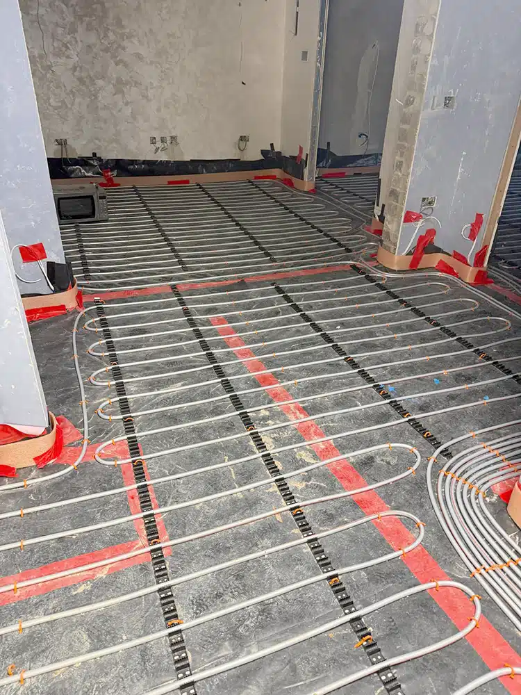 Underfloor heating pipes with red flow pipes before screeding